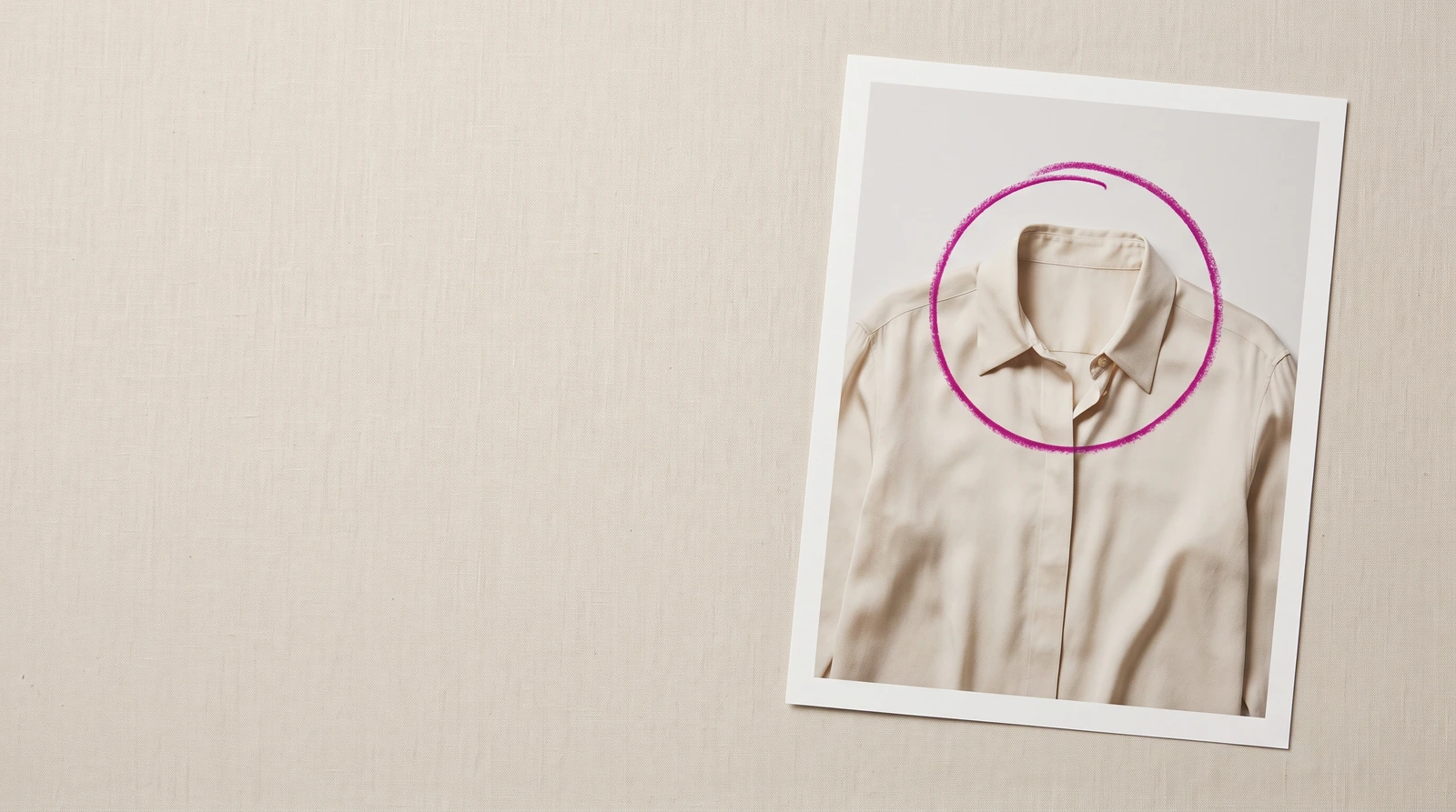 A single photographic print lying flat on a pale studio table, one magenta grease-pencil circle drawn around the collar of the garment it shows, nothing else in the room